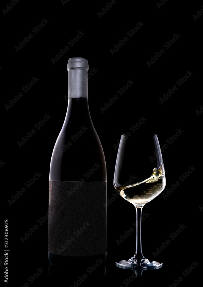 A bottle of precious white wine along with a glass. The wine in the glass moves and creates a dynamic effect. A bottle of precious white wine along with a glass. The wine in the glass moves and creates a dynamic effect.