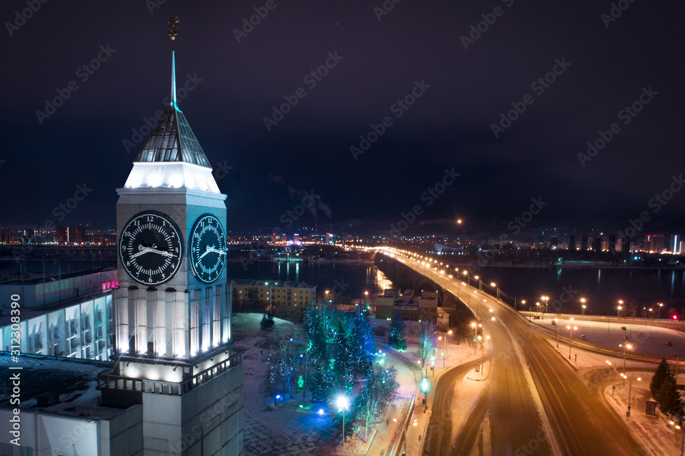 Сity administration with main clock tower overlooking bridge across Yenisei. View from above