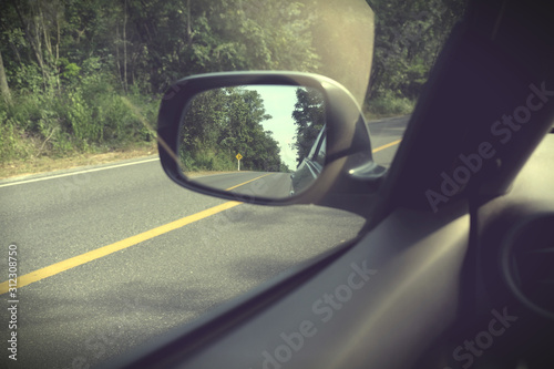 Landscape in the side view mirror of a car, on road countryside, natural © bebuntoon
