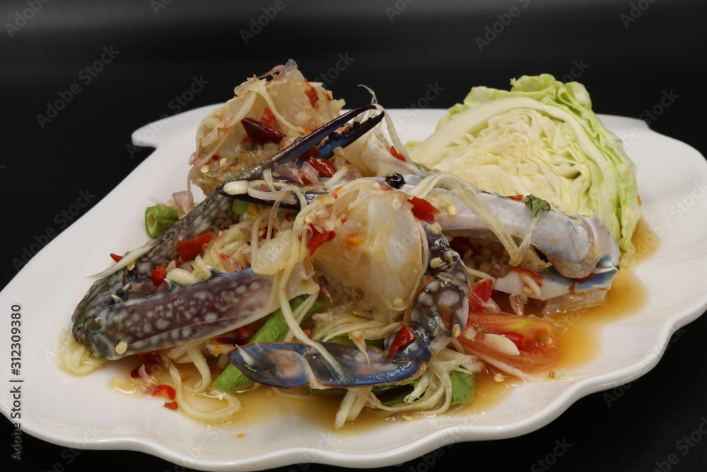 Somtum (Thai spicy salad) with raw crab and vegetable in white plate