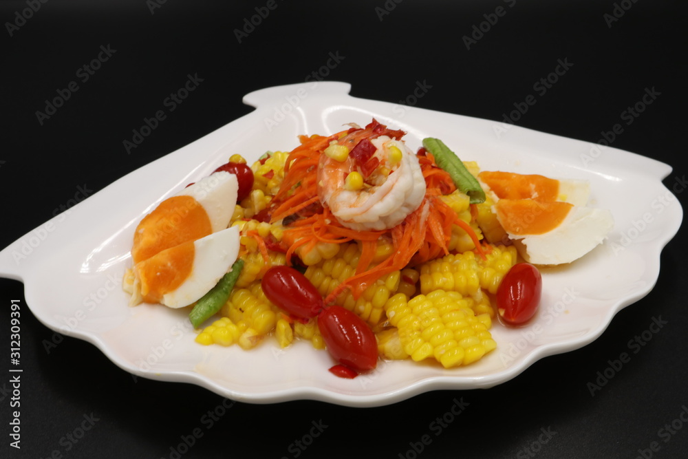 Thai spicy salad with prawn, corn and salted egg in white plate