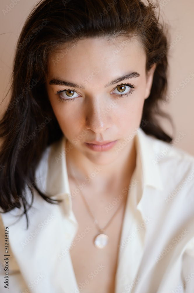 Beautiful young woman posing on beige wall background. Beautiful young woman posing on beige wall background.