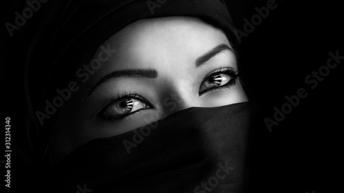 Young woman in hijab on black background photo