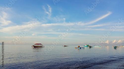  Fishing boats are on the beach, with a view of the sea and blue sky