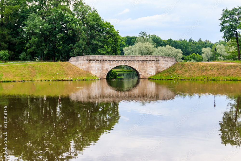 Stone arch bridge across a lake in Gatchina, Russia