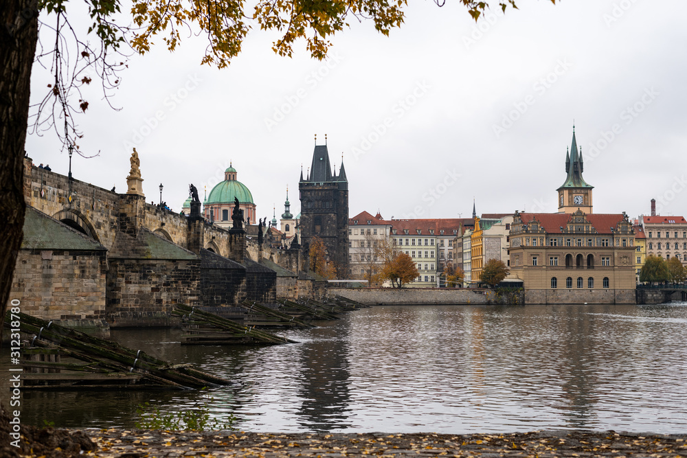 Charles bridge and tower in Prague on a cloudy day in autumn