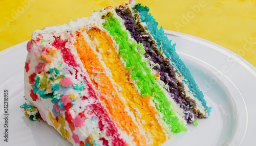 Un trozo de pastel arcoirirs (una apetecible y deliciosa tarta para fiestas). photo