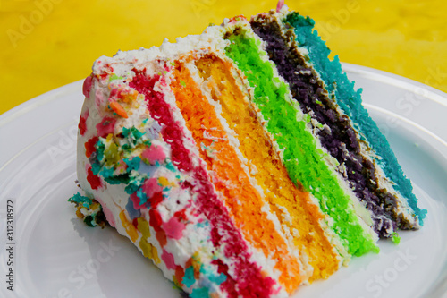 Un trozo de pastel arcoirirs (una apetecible y deliciosa tarta para fiestas). photo