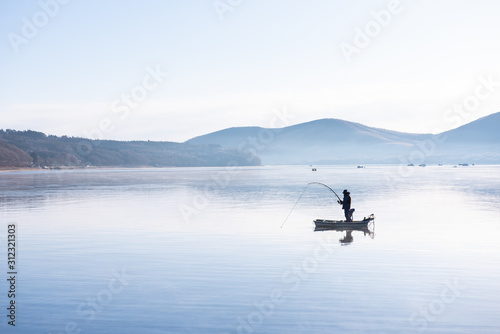 Fisherman on the little boat in lake yamanaka morning