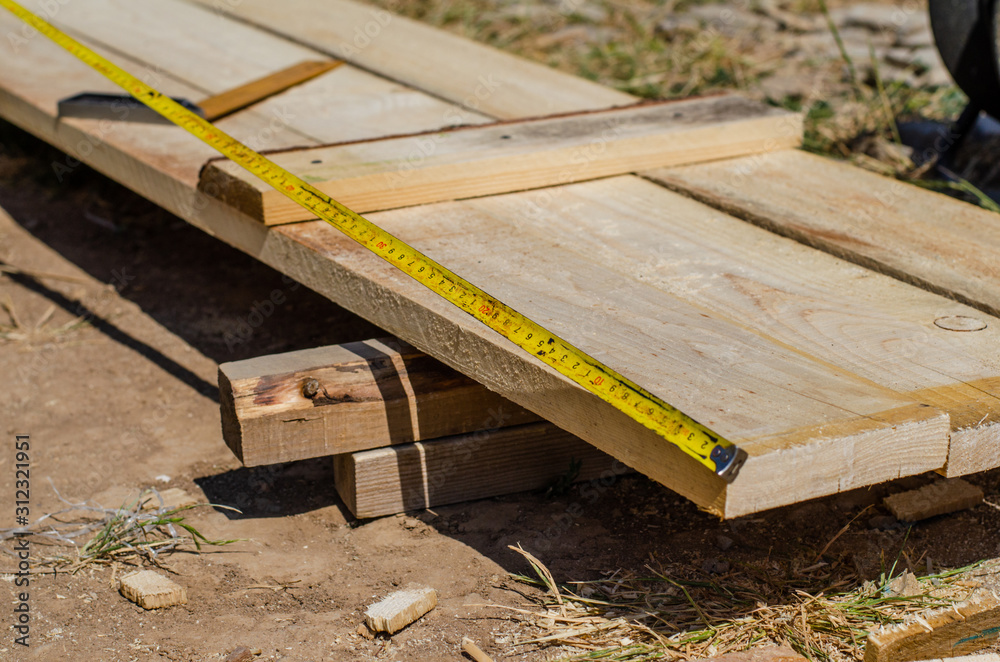 Fototapeta premium yellow measuring tape measures the formwork boards