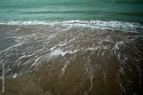 Fototapeta Naklejka Na Ścianę i Meble -  Soft wave of blue ocean on sandy beach. Background.