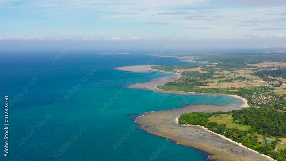 Agricultural fields and villages on the island, top view. Coral reefs off the coast and turquoise lagoons. Luzon Island, Philippines. Summer and travel vacation concept. Agricultural fields and villages on the island, top view. Coral reefs off the coast and turquoise lagoons. Luzon Island, Philippines. Summer and travel vacation concept.