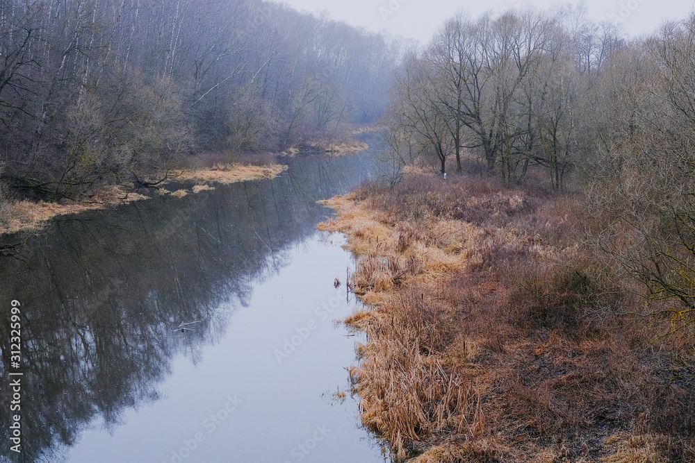 Autumn landscape. A small river overgrown with trees in the early foggy morning of late autumn. Autumn landscape. A small river overgrown with trees in the early foggy morning of late autumn.