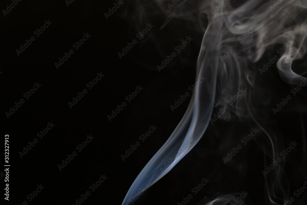 Abstract smoke background with copy space on black background. Blue-white smoke rising from the incense stick Abstract smoke background with copy space on black background. Blue-white smoke rising from the incense stick