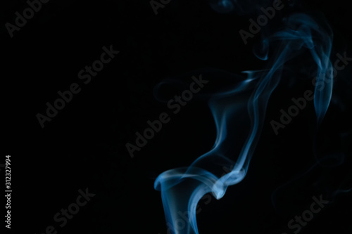 Beautiful abstract blue smoke with copy space on black background. Smoke background for art design or drawing. Abstract figure of the smoke