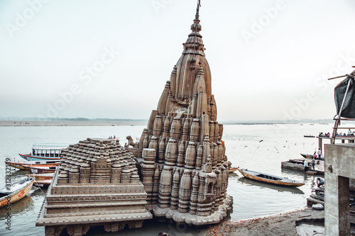 Ratneshwar Mahadev Mandir Temple in Varanasi, the famous crooked temple half submerged in the water of the holy river Ganges. Architectural details. photo