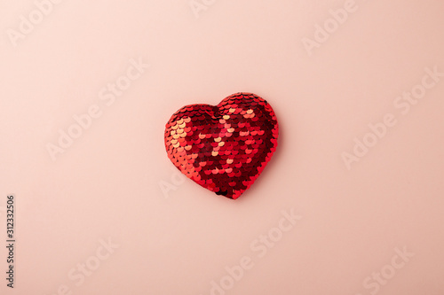 Red glitter heart on pink background