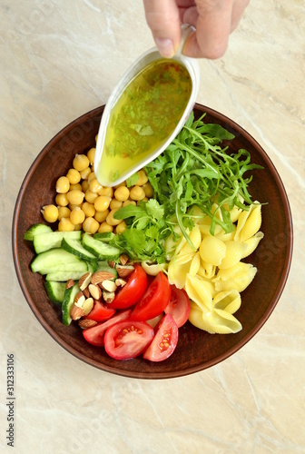 Mediterranean pasta salad with vegetables and chickpeas, vertical, top view 