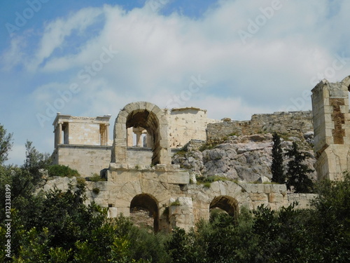 An arch of the Odeon of Herodes Atticus, or Herodeon, and the temple of Athena Nike, on the Acropolis, in Athens, Greece