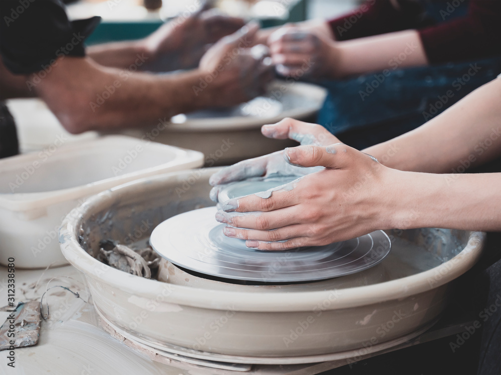 Guy throw a pot craftsman teaching how to molding clay vessel on pottery wheel crafts workshop Guy throw a pot craftsman teaching how to molding clay vessel on pottery wheel crafts workshop