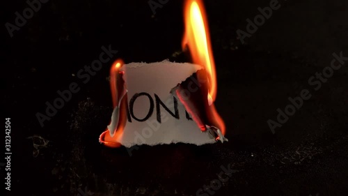 Monday word written on white paper burns. Fire with smoke and ashes on black background photo