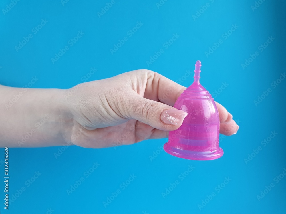 Fototapeta premium latex menstrual Cup in a woman's hand, an alternative hygiene product for women during the menstrual period.