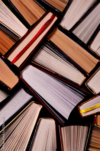 Books. Lots of colourful thick open books stand on a dark background