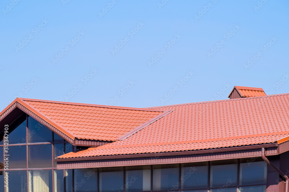 A building with a red-brown roof. Modern materials of finish and roofing