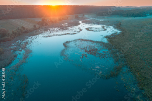 Early foggy morning. Sunrise over the lake. Rural landscape in the summer. Aerial view
