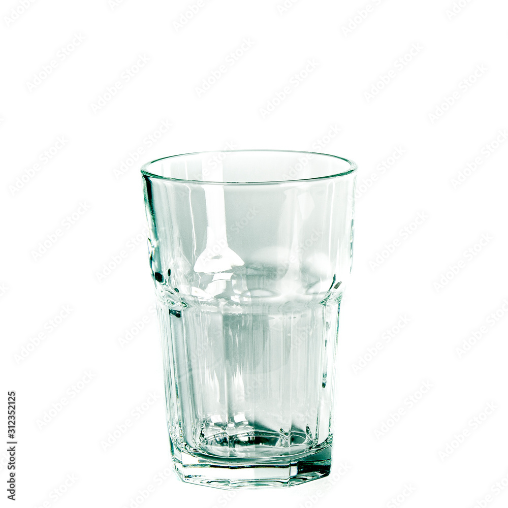 An empty glass and a carafe for water stand on a white background An empty glass and a carafe for water stand on a white background