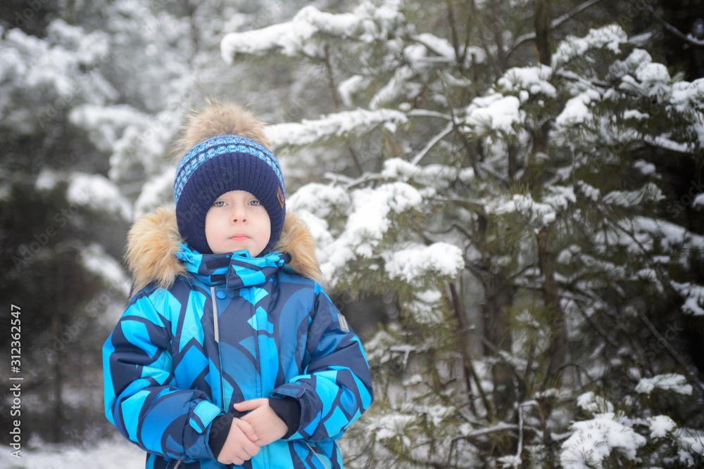 Boy in warm clothes in the winter forest Boy in warm clothes in the winter forest