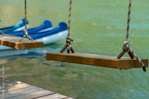 Wooden Swing and Conoe in Background photo