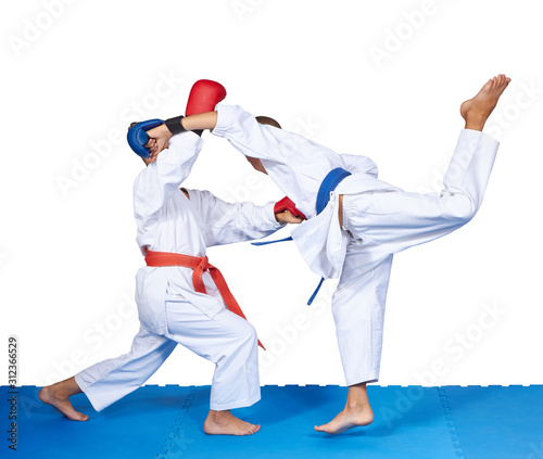 Two children in karategi are training karate blows