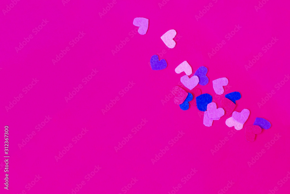 Pink background with colorful felt hearts. Top view. Copy space. Place for text and design.