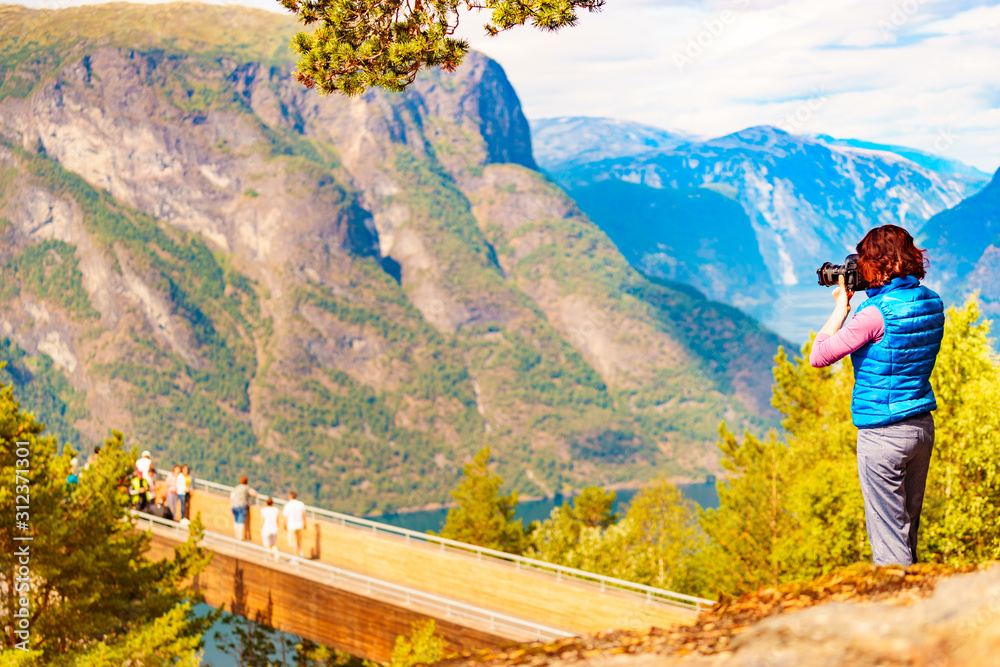 Naklejka premium Tourist on nature take travel picture, Norway