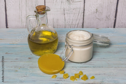 Facial cream of homemade olive oil in glass jar, with pieces of virgin beeswax. Medicine and alternative health. photo