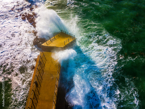 Aerial view of a pier with rocks and rocks on the sea. Pizzo Calabro pier, panoramic view from above. Broken pier, force of the sea. Power of Waves. Natural disasters, climate change. Calabria. Italy