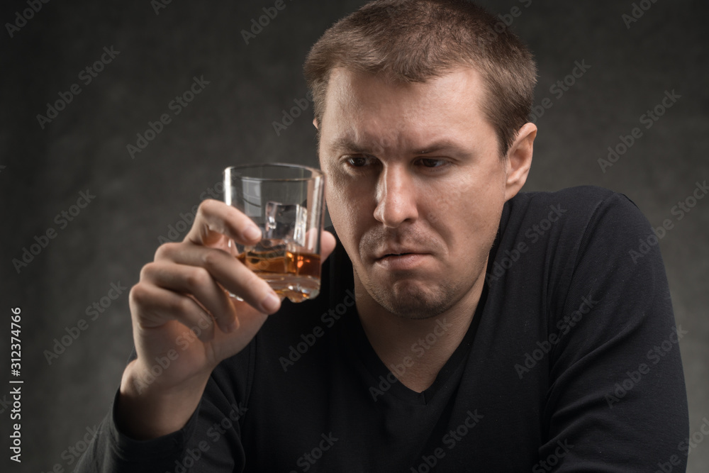 Alcoholic addict. Man near the table with alcohol and a glass. Dangerous habit. Unhealthy life concept. Social problem. Alcoholic addict. Man near the table with alcohol and a glass. Dangerous habit. Unhealthy life concept. Social problem.