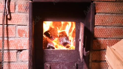 Fire in the classic russian bathhouse furnace. Tipical village life