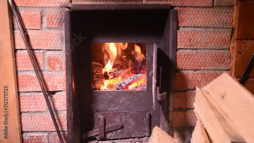 Fire in the classic russian bathhouse furnace. Tipical village life
