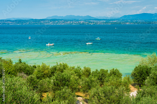 Fototapeta Naklejka Na Ścianę i Meble -  Jamaica Beach at Sirmione, on Lake Garda, renowed for its beautiful emerald water. Province of Brescia, Lombardy, Italy.