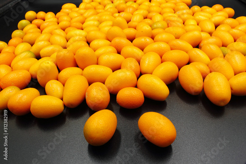 fresh orange citrus Kumquat fruit isolated on a black background photo