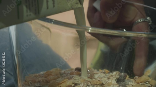 Pouring Milk Into Breakfast Cereal, Outdoors Camping Closeup. photo