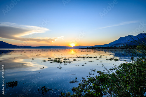 Short grass and vegitation on the right corner of Lake Chapala during sunset in Ajijic Mexico