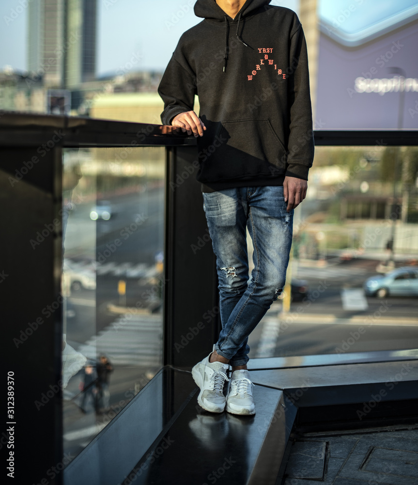 Teenager wearing a pair of white Nike Huarache, denim and hoodie Stock  Photo | Adobe Stock