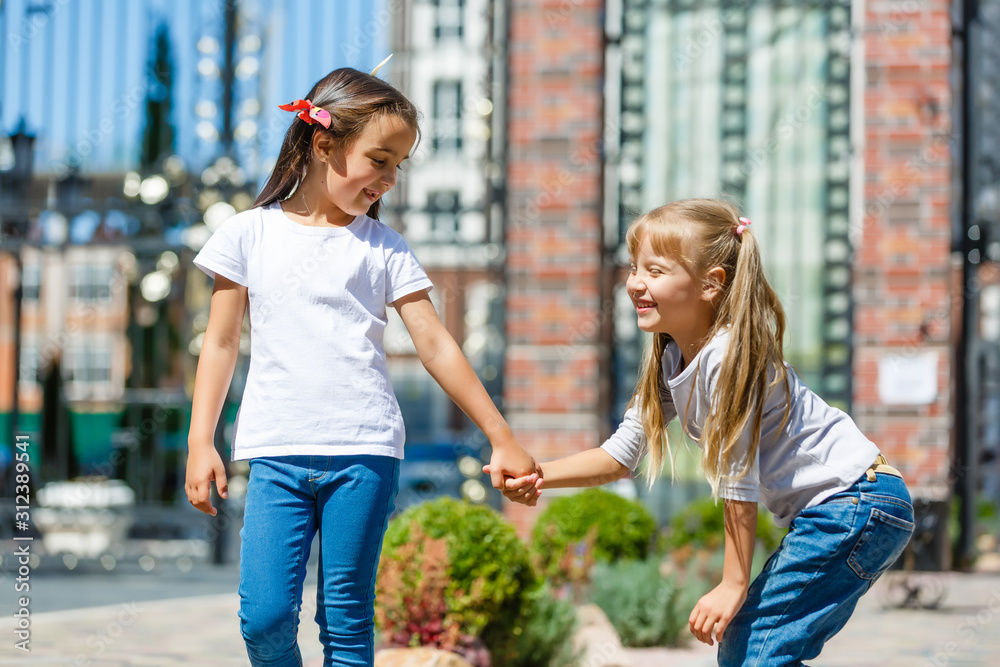 Two beautiful little girls on a swings outdoor in the playground at summertime Two beautiful little girls on a swings outdoor in the playground at summertime