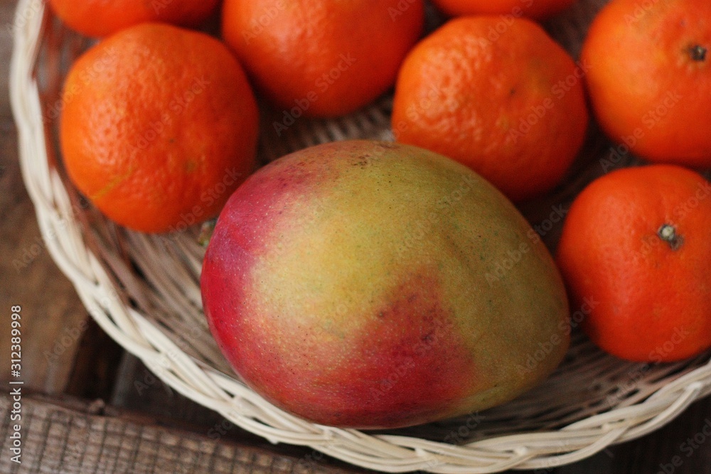 Fresh mango and tangerines on the table Fresh mango and tangerines on the table