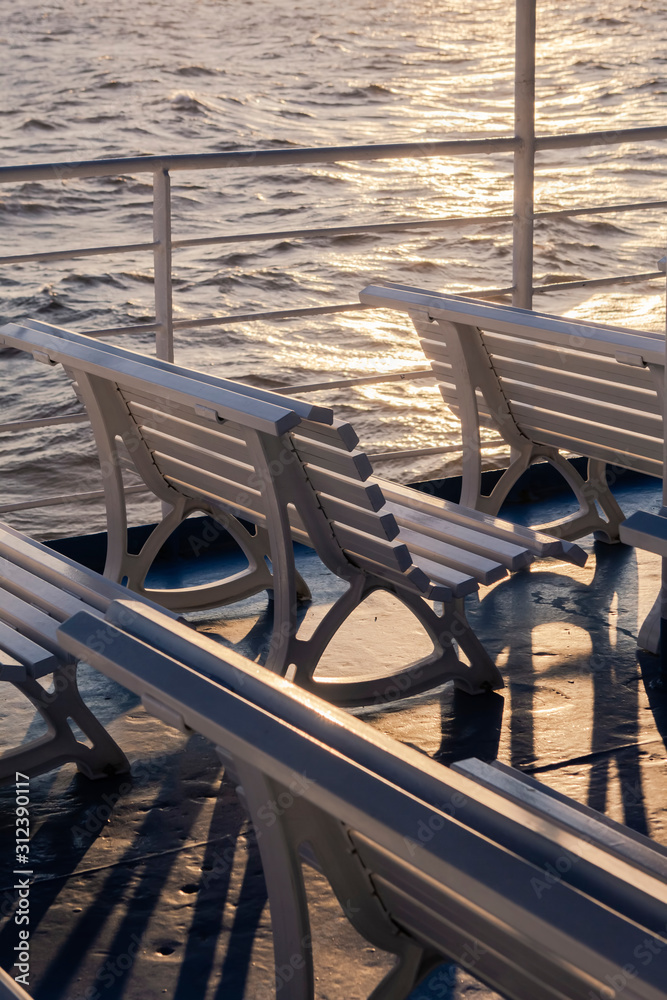 Empty rows of benches on passenger boat traveling the Greek Islands with no passengers Empty rows of benches on passenger boat traveling the Greek Islands with no passengers