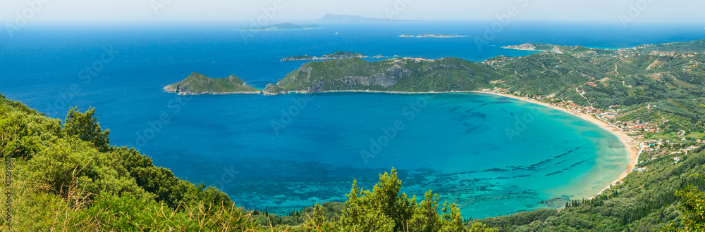 Stretching panorama from the road to Angelokastro, View of the bay of Agios Georgios Pagon and the azure sea.