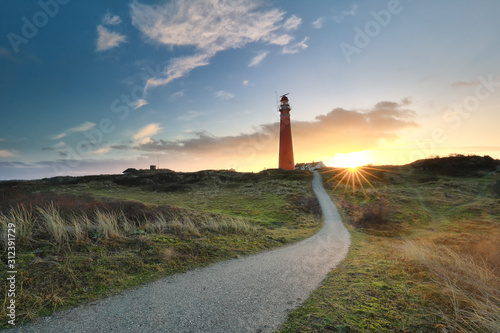 path to red lighthouse at sunrise